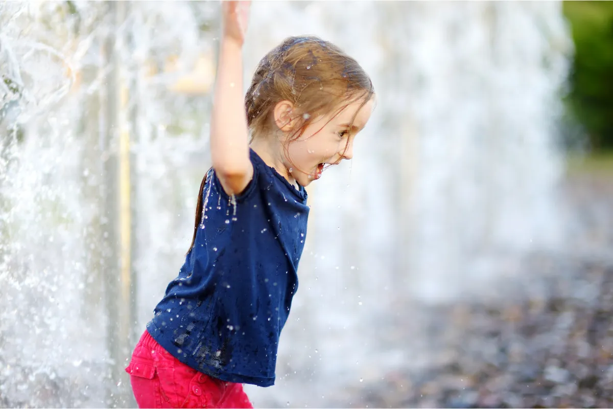 Dziecko bawiące się przy fontannie.