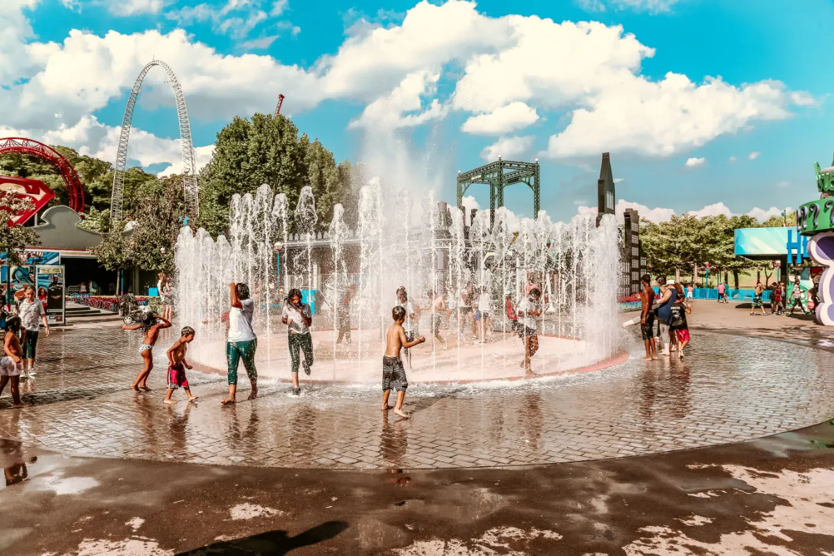 Ludzie bawiący się przy fontannie.